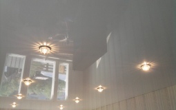 Белый глянцевый потолок с точечными светильниками для спальни